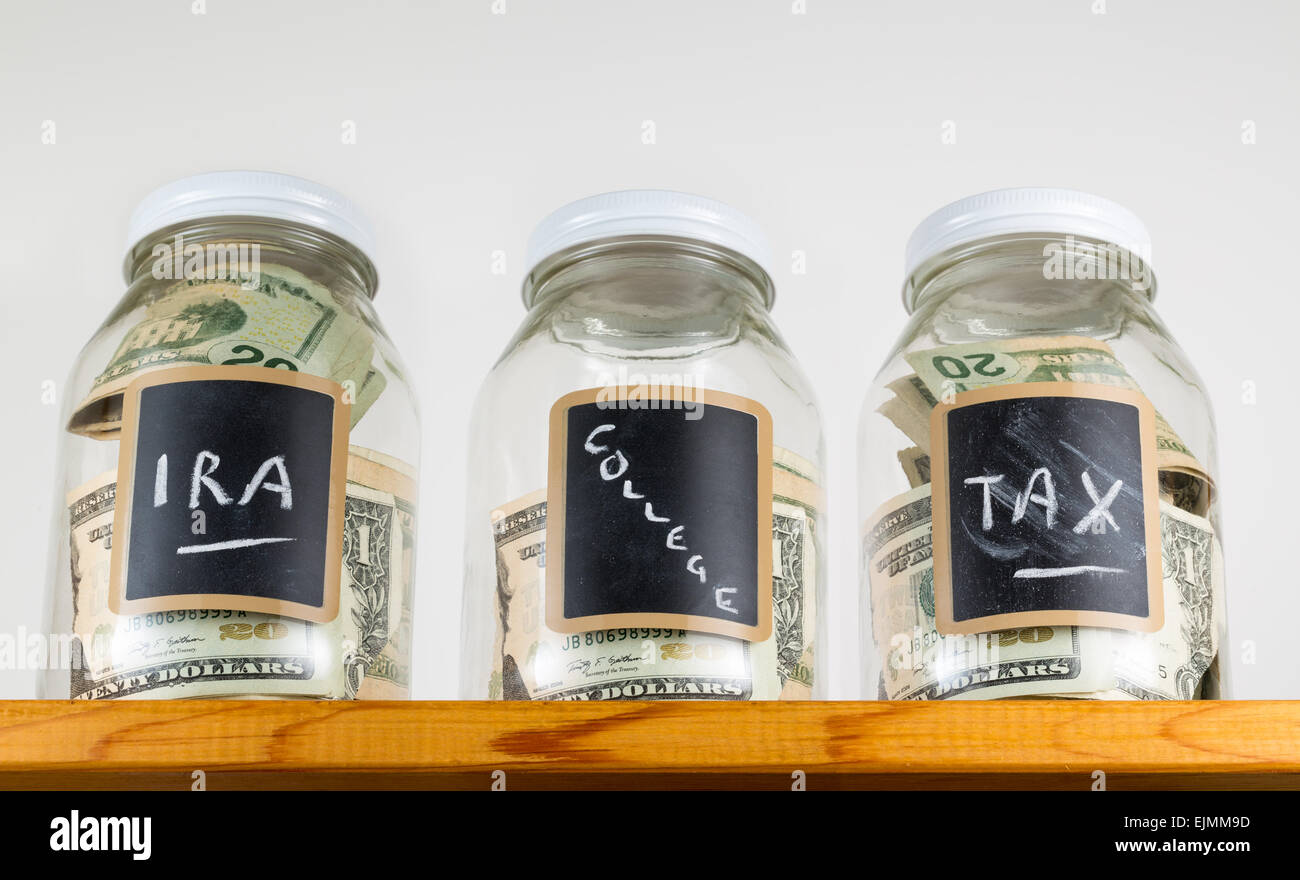 Tre vasi di vetro con chalk etichette utilizzate per il salvataggio di US Dollar Bills e note per ira, fiscali e fondi college Foto Stock