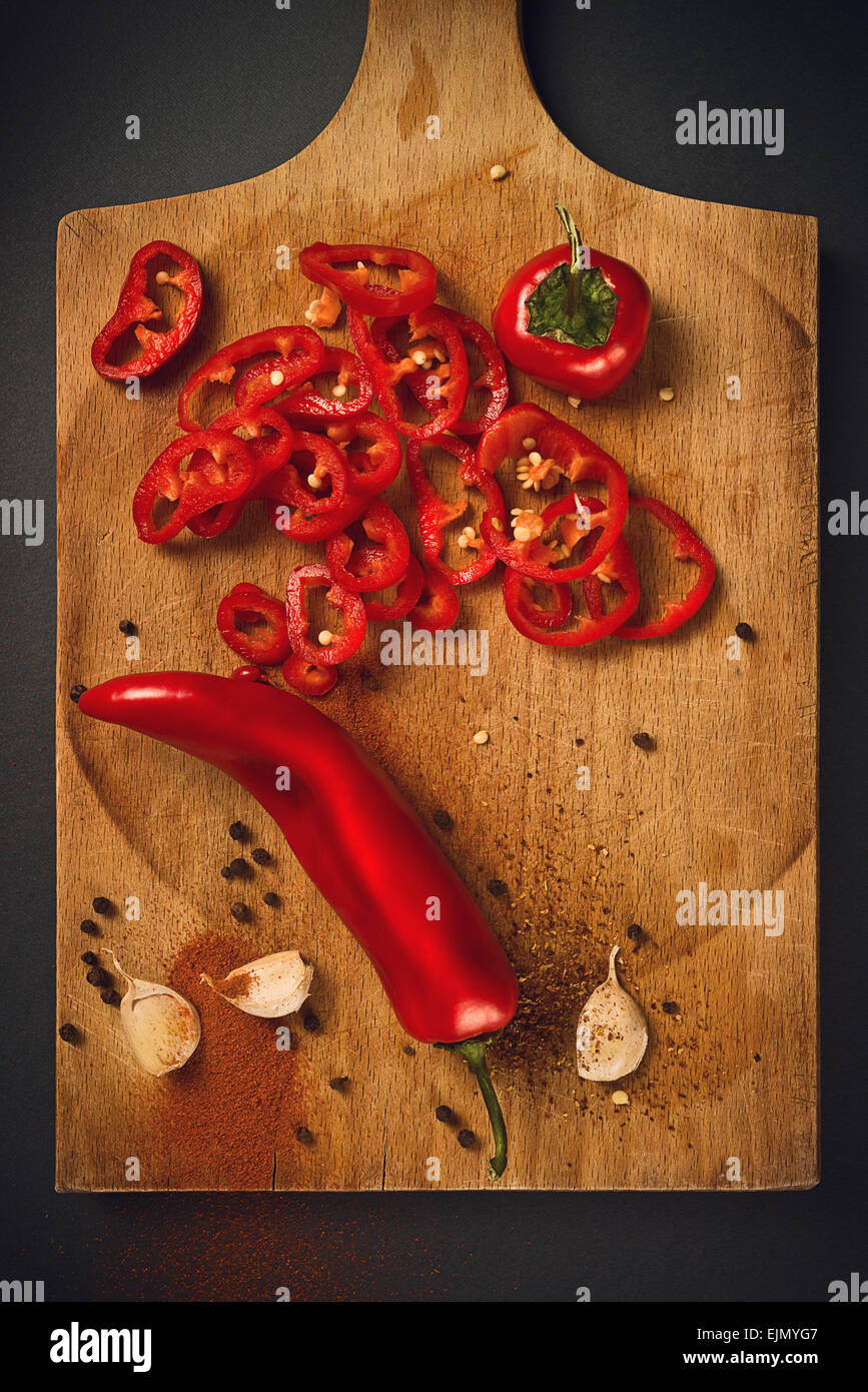 Red Hot Chili Pepper, spezie e aglio organico sulla cucina in legno piastra come cibo caldo ingredienti per piccante cucina piccante. Foto Stock