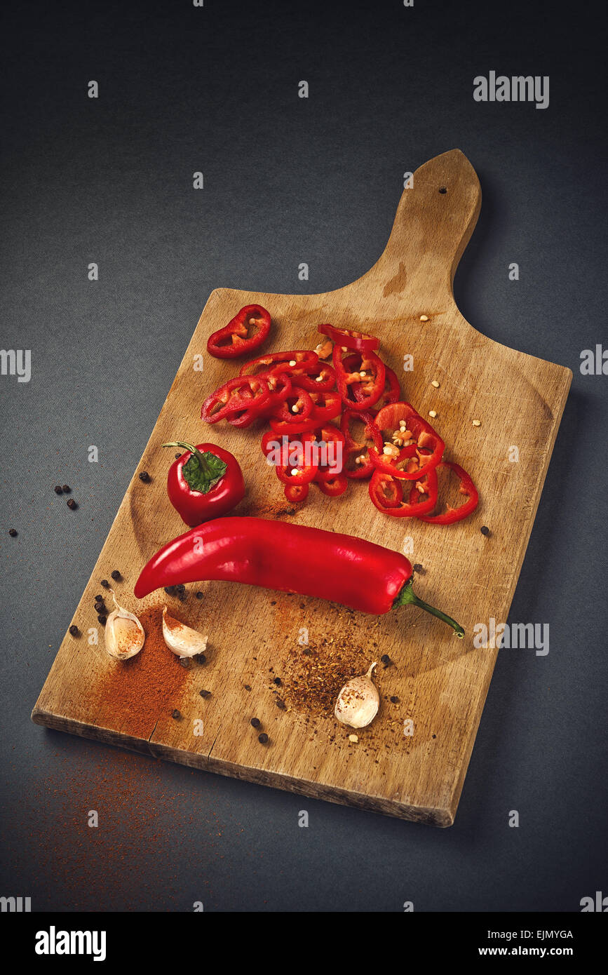 Red Hot Chili Pepper, spezie e aglio organico sulla cucina in legno piastra come cibo caldo ingredienti per piccante cucina piccante. Foto Stock