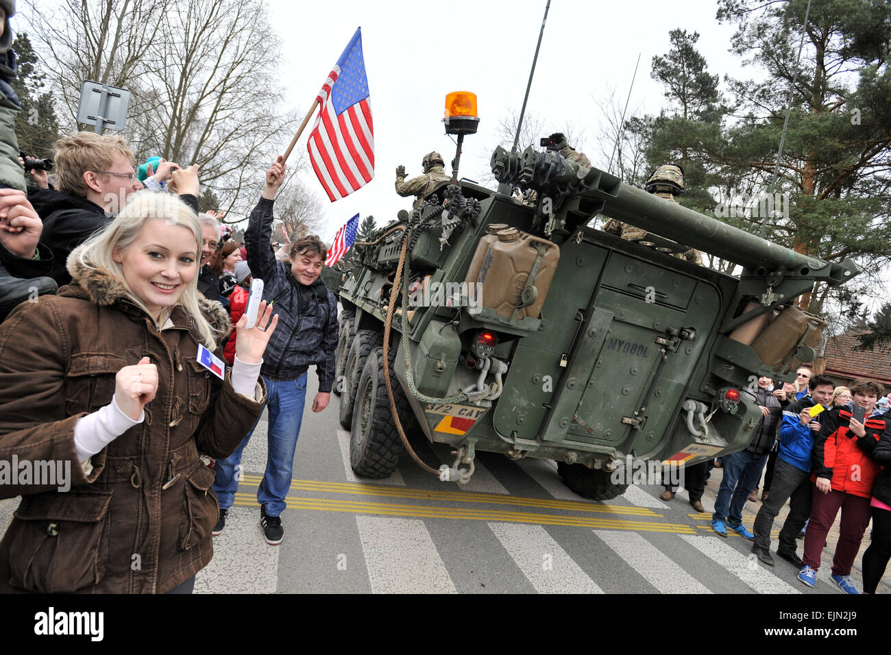 Persone con bandiere ci è venuto a dare il benvenuto a un gruppo di US Army Stryker veicoli corazzati durante il passaggio di Vyskov, Repubblica Ceca, domenica 29 marzo, 2015, come essi guidare indietro dall'Atlantico risolvere esercizio. Il 'Dragoon Ride' convoglio, progettato per mostrare la disponibilità della NATO a difendere i suoi membri, ha iniziato la settimana scorsa da Estonia e fatto passare attraverso la Lettonia, la Lituania e la Polonia prima di entrare nella Repubblica ceca sulla sua strada verso la base in Vilseck, Germania. (CTK foto/Vaclav Salek) Foto Stock