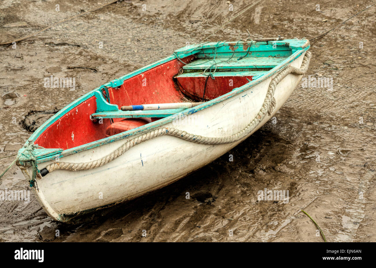 La bassa marea nel porto di Polperro, Cornwall, Inghilterra, Regno Unito. Una pesca dinghy attende il ritorno della marea. Foto Stock