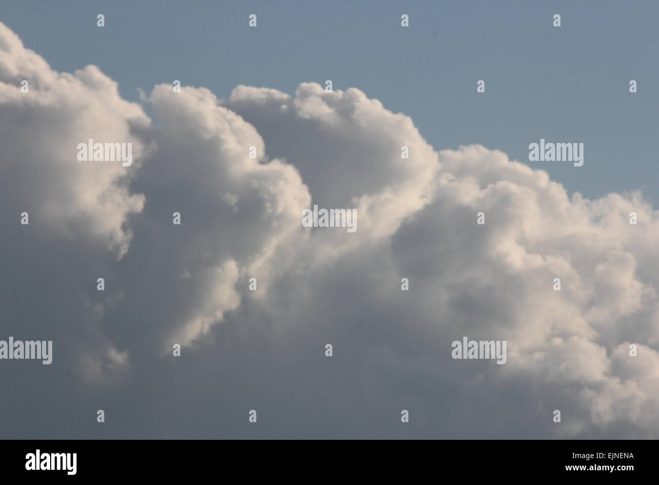 Sventolano nuvole bianche contro un oscuramento cielo blu nel tardo pomeriggio. Foto Stock