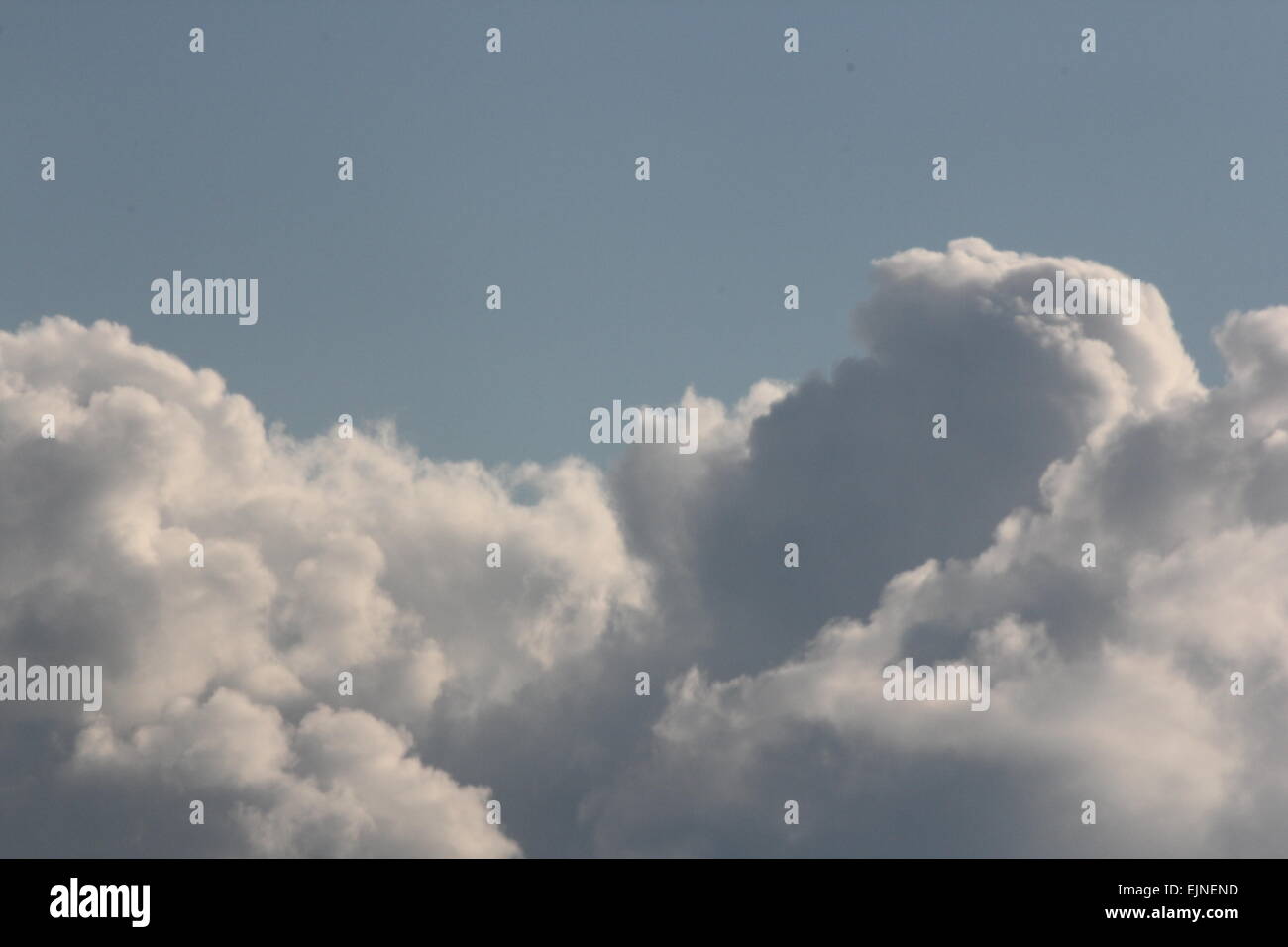 Sventolano nuvole bianche contro un oscuramento cielo blu nel tardo pomeriggio. Foto Stock