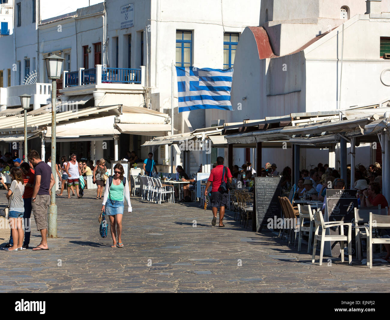 Mykonos, Grecia city walk cafè e flag Foto Stock