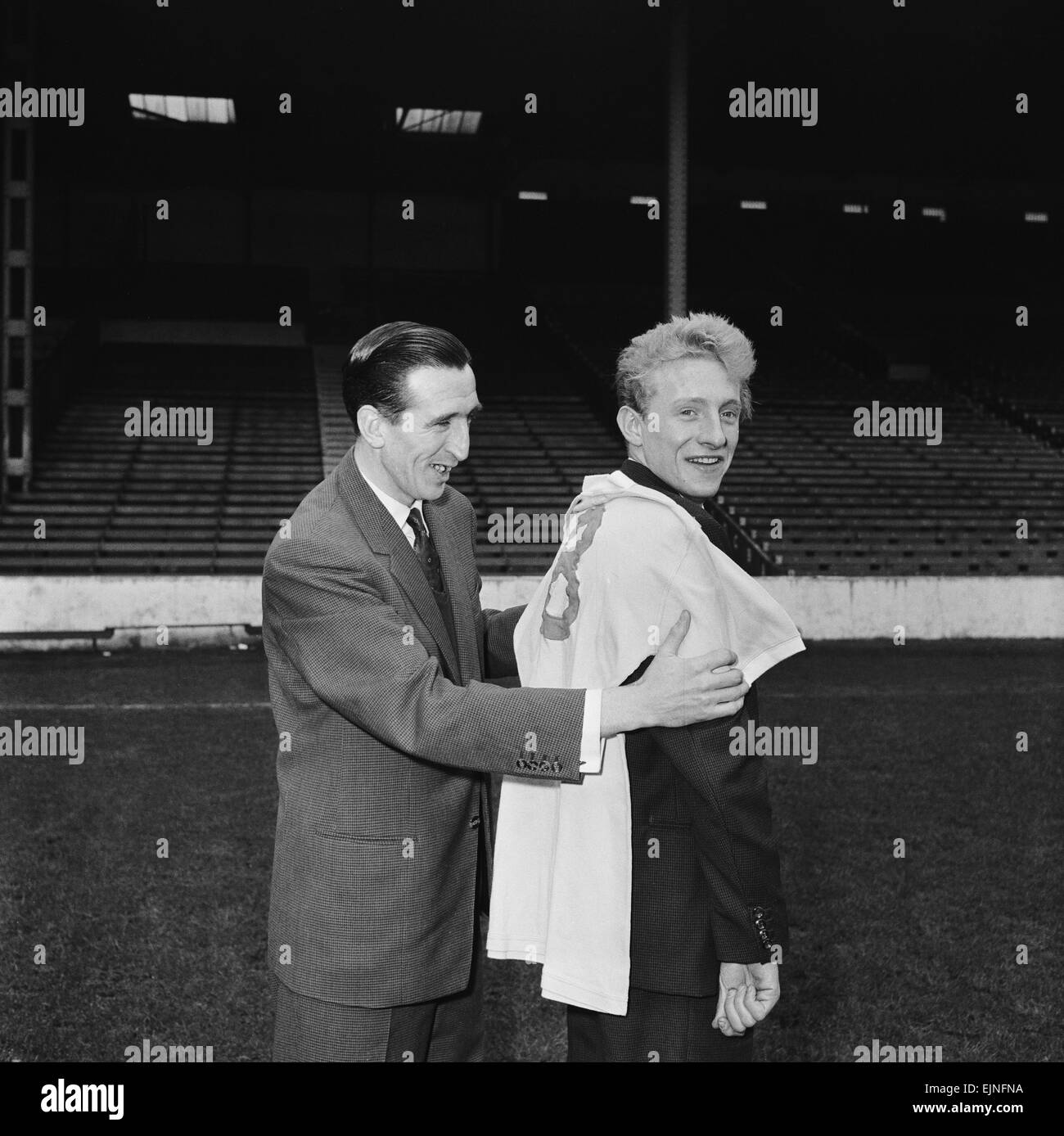 Manchester City nuova firma Denis legge con Ken Barnes cercando la sua nuova maglia per dimensioni. 16 marzo 1960. Foto Stock