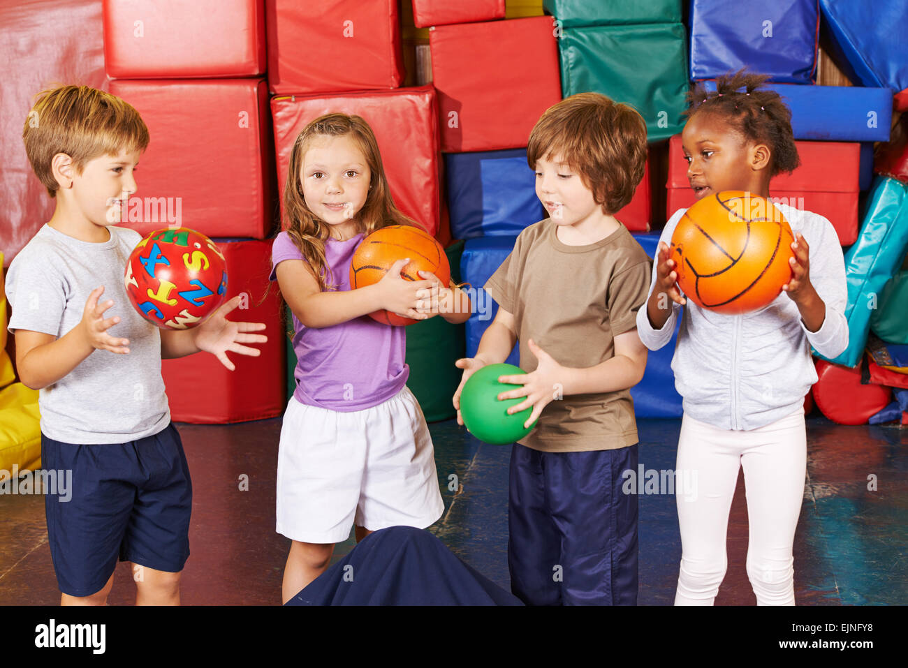Bambini che giocano con le diverse sfere nella palestra della scuola  materna Foto stock - Alamy