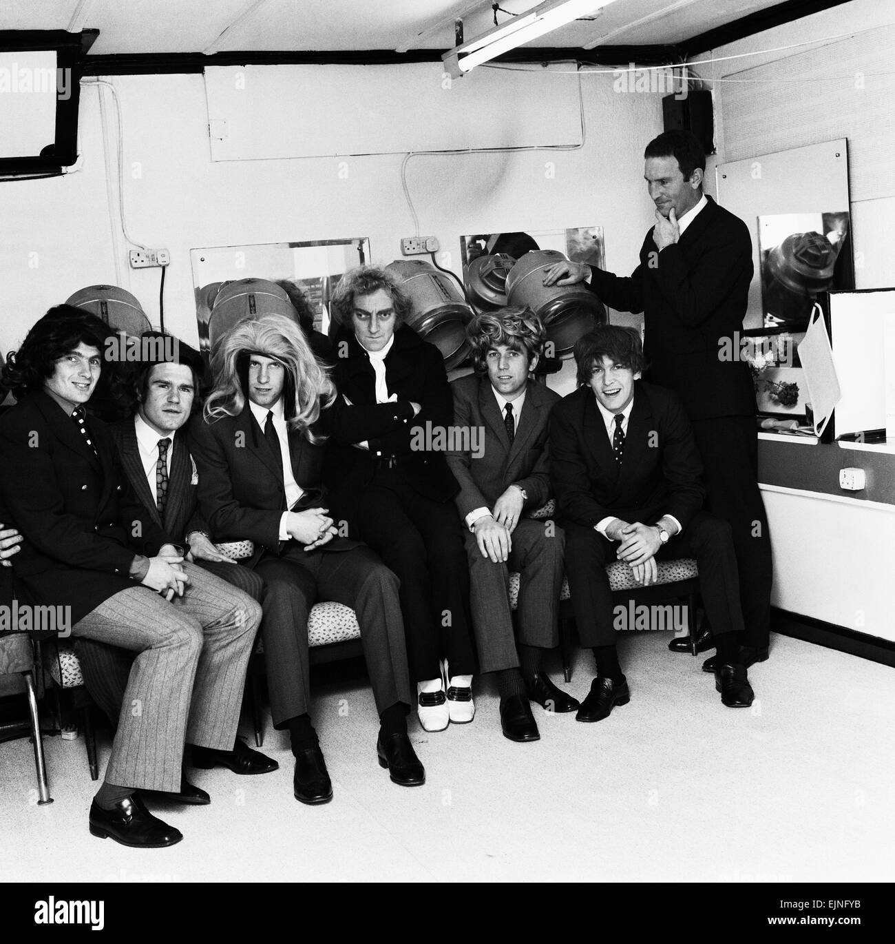 David Webb (destra in piedi) visto qui con altri giocatori del Chelsea Peter Osgood Marvin Hinton Dave Sexton Charlie Cook Tommy Baldwin e comico Marty Feldman (centro) all'apertura di una parrucca boutique e parrucchiere in Chelsea. 17 Novembre 1969 Foto Stock