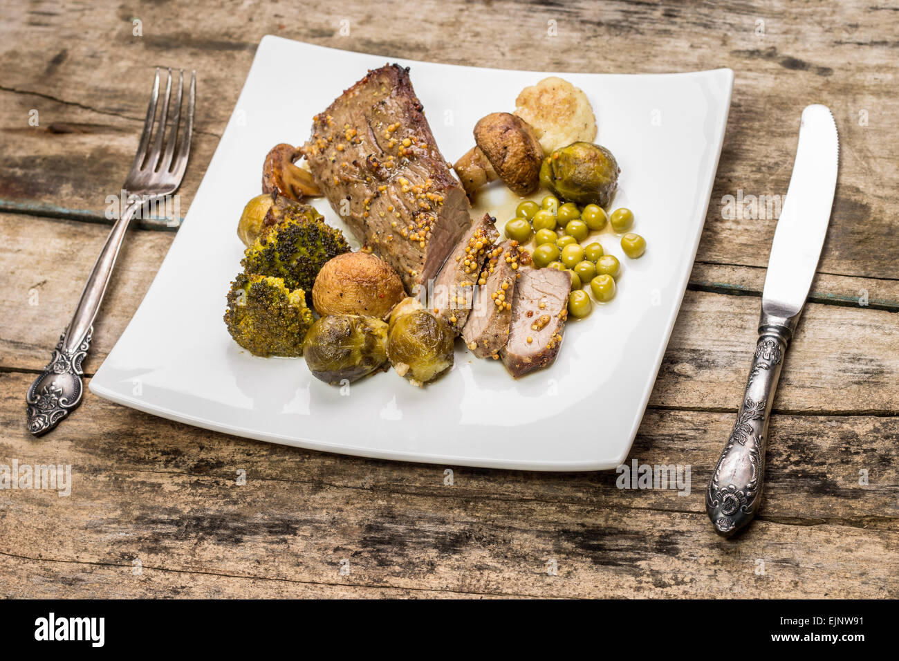 Manzo alla griglia con i cavolfiori, broccoli, i funghi e i cavoli di Bruxelles sul tavolo di legno. Alimenti Eco sullo sfondo Foto Stock