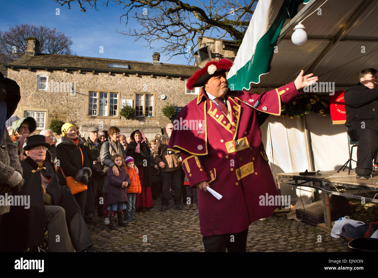 Regno Unito, Inghilterra, Yorkshire, Grassington, Dickensian Festival, Town Crier Victor Watson annunciando band Foto Stock