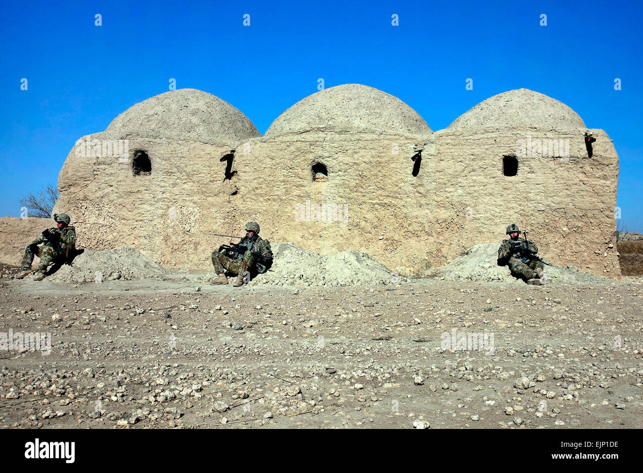 Soldati dal 2° Stormo, 38th reggimento di cavalleria, 504th Battlefield brigata, appoggiarsi contro un muro di fango durante una pausa dalle operazioni di combattimento nella provincia di Kandahar il sud di Spin Boldak distretto. Foto Stock