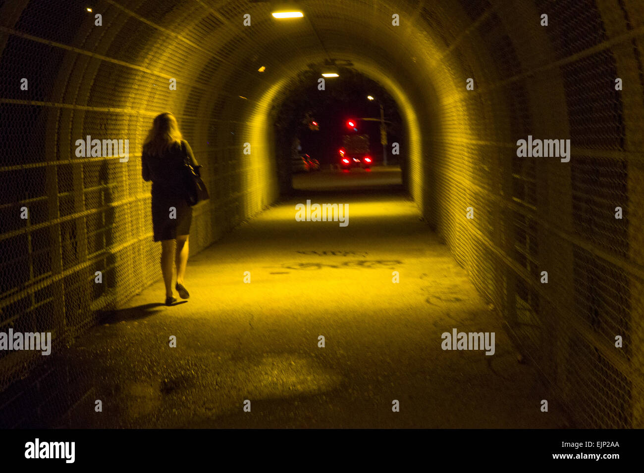 Donna che cammina da solo attraverso bridge Foto Stock