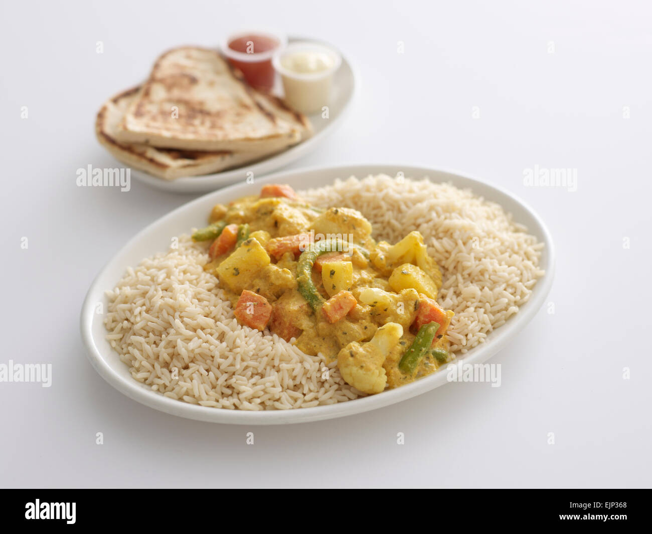 Pasto su un piatto di verdura Korma riso con pane Naan e salse Foto Stock