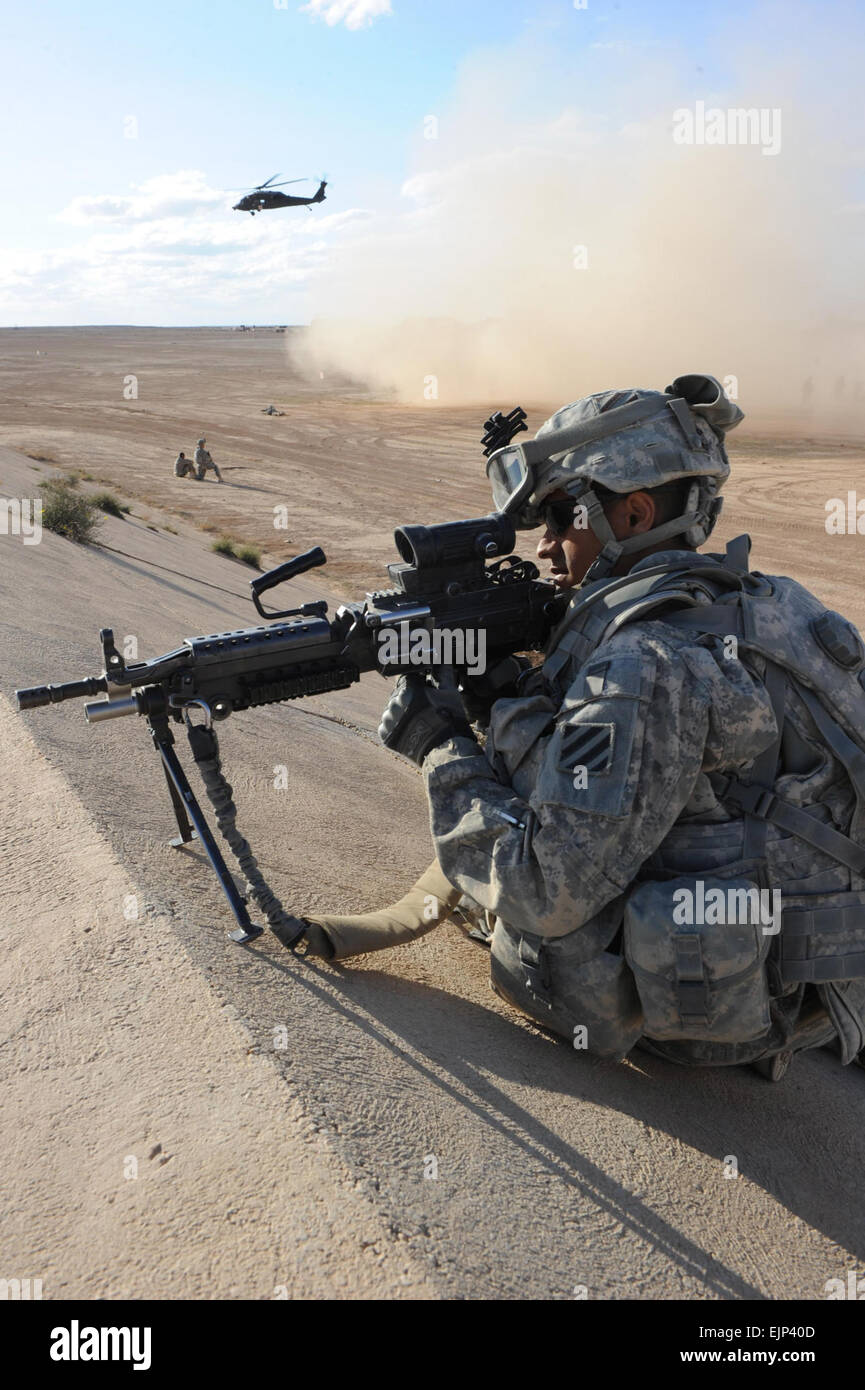 Stati Uniti Pfc dell'esercito. Franklin Delacruz fornisce la sicurezza per un'aria evacuazione medica presso l'Al Asad Airbase, Iraq, il 11 marzo 2011. Delacruz è assegnato alla società alfa, 3° Battaglione, 7° Reggimento di Fanteria, 4a consigliare e assistere brigata, terza divisione di fanteria. I soldati della 4a consigliare e assistere la brigata con l'assistenza di soldati assegnati a Charlie Company, 3° Battaglione, 126Reggimento di aviazione, Massachusetts Guardia Nazionale, hanno partecipato a casualty esercitazione di evacuazione. Spc. Gary Silverman, U.S. Esercito. Rilasciato Foto Stock