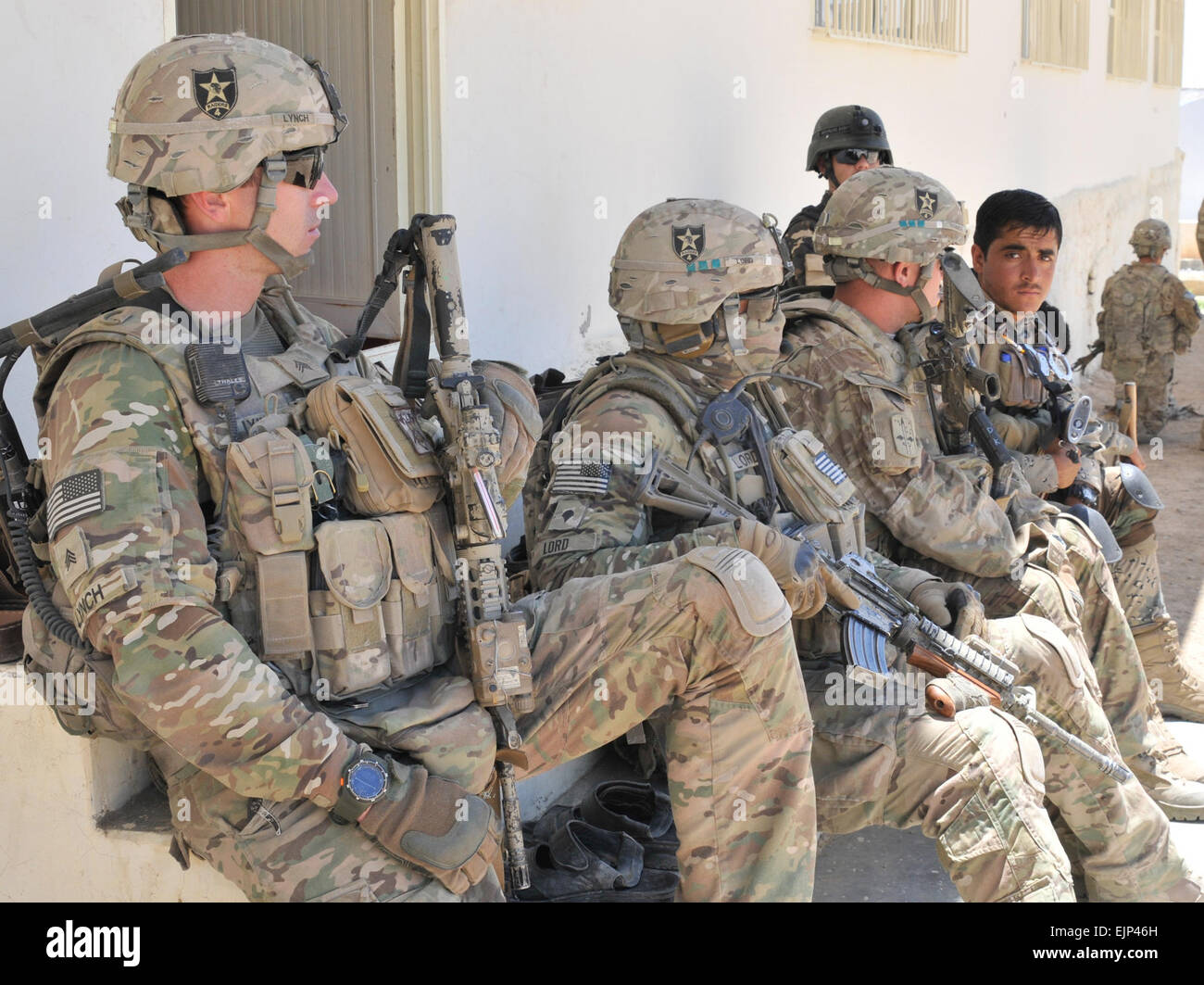 Soldati con 2° Battaglione, XXIII Reggimento di Fanteria lungo con la frontiera afgana e uniforme della polizia prendono una pausa seduto mentre fornendo sicurezza durante un Afghan Programma di pace e riconciliazione nella provincia di Kandahar, Afghanistan. Il personale Sgt. Shane Hamann. Foto Stock