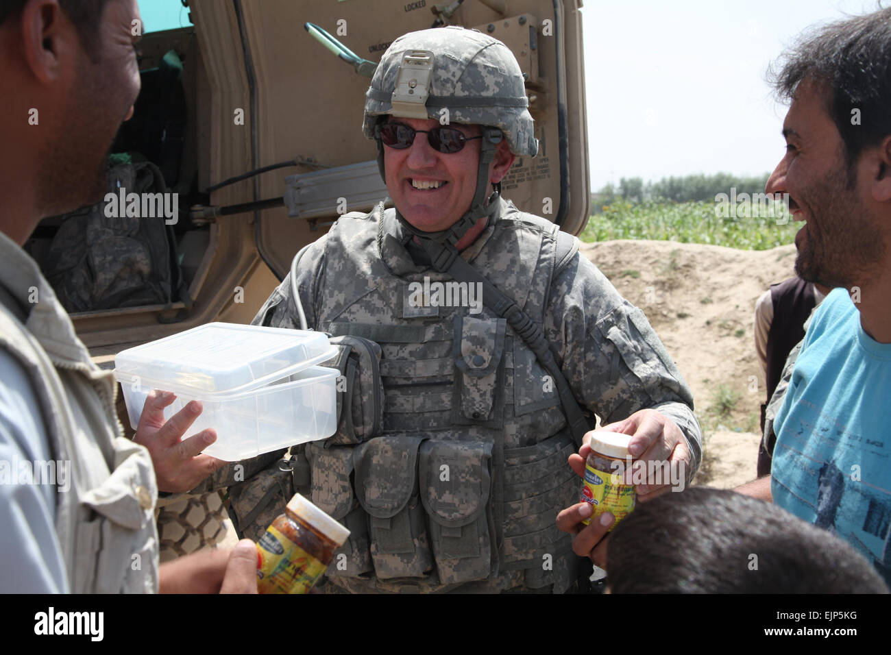 Stati Uniti Esercito il Mag. Michael Gardner, con un civile e militare del team di supporto consente di vasi di marmellata di residenti nel villaggio di Bahshekel nel Parwan provincia dell'Afghanistan su agosto 29, 2010. Civile il supporto militare dei membri del team e un sud coreano provincial reconstruction team ha visitato il villaggio di ispezionare un sito di irrigazione. Spc. Kristina L. Gupton, U.S. Esercito. Rilasciato Foto Stock