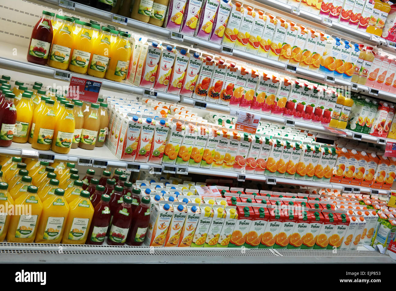 La Vallonia, Belgio - Ottobre 2014: ripiani refrigerati con una varietà di bottiglie di succo in un Ipermercato Carrefour Foto Stock