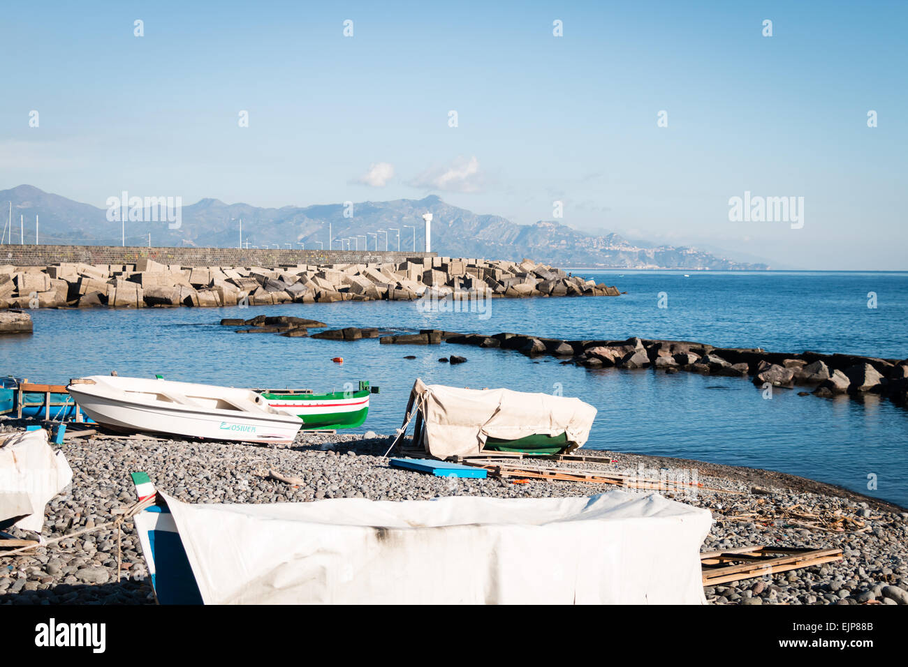 Porto di Riposto con il faro e le rocce di protezione Foto Stock