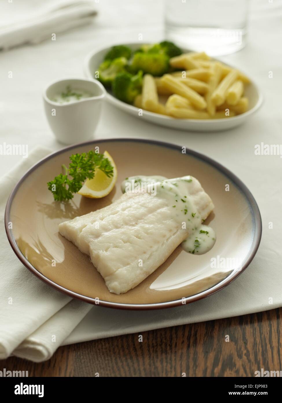 Pasto placcati di pianura filetto di eglefino o baccalà con limone prezzemolo e salsa Foto Stock