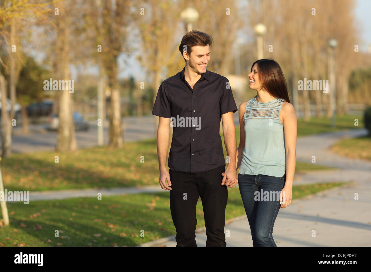 Coppia felice ridere mentre facendo una passeggiata in un parco Foto Stock