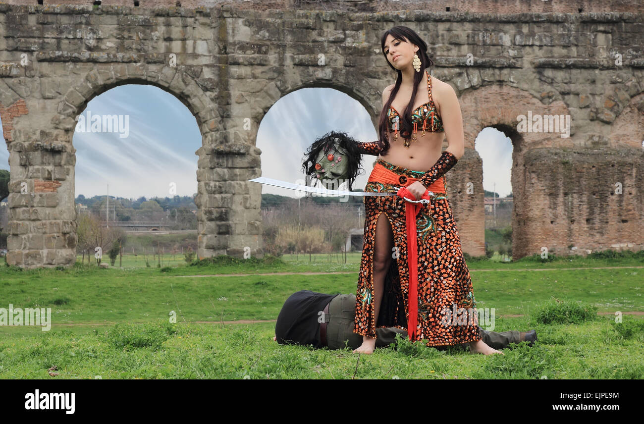 Oriental' odalisca con spada e morti decapitati monster Foto Stock