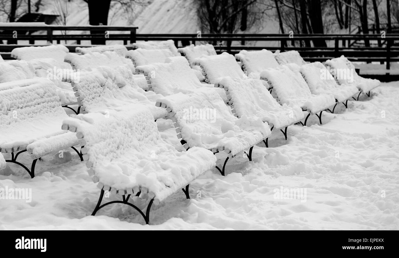 Bella coperta di neve panche nel Parco in inverno Foto Stock
