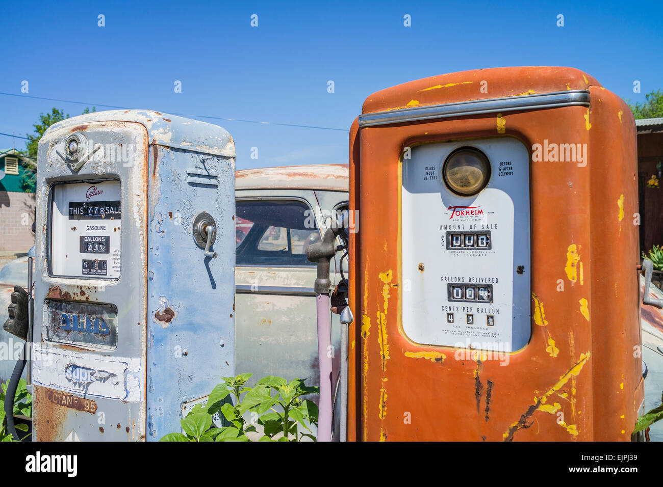 Un 1947 Chrysler berlina 4 porte la formazione di ruggine con vernice sbiadita siede parcheggiata di fronte due vecchio stile pompe di gas in corrispondenza di una stazione di riempimento. Foto Stock