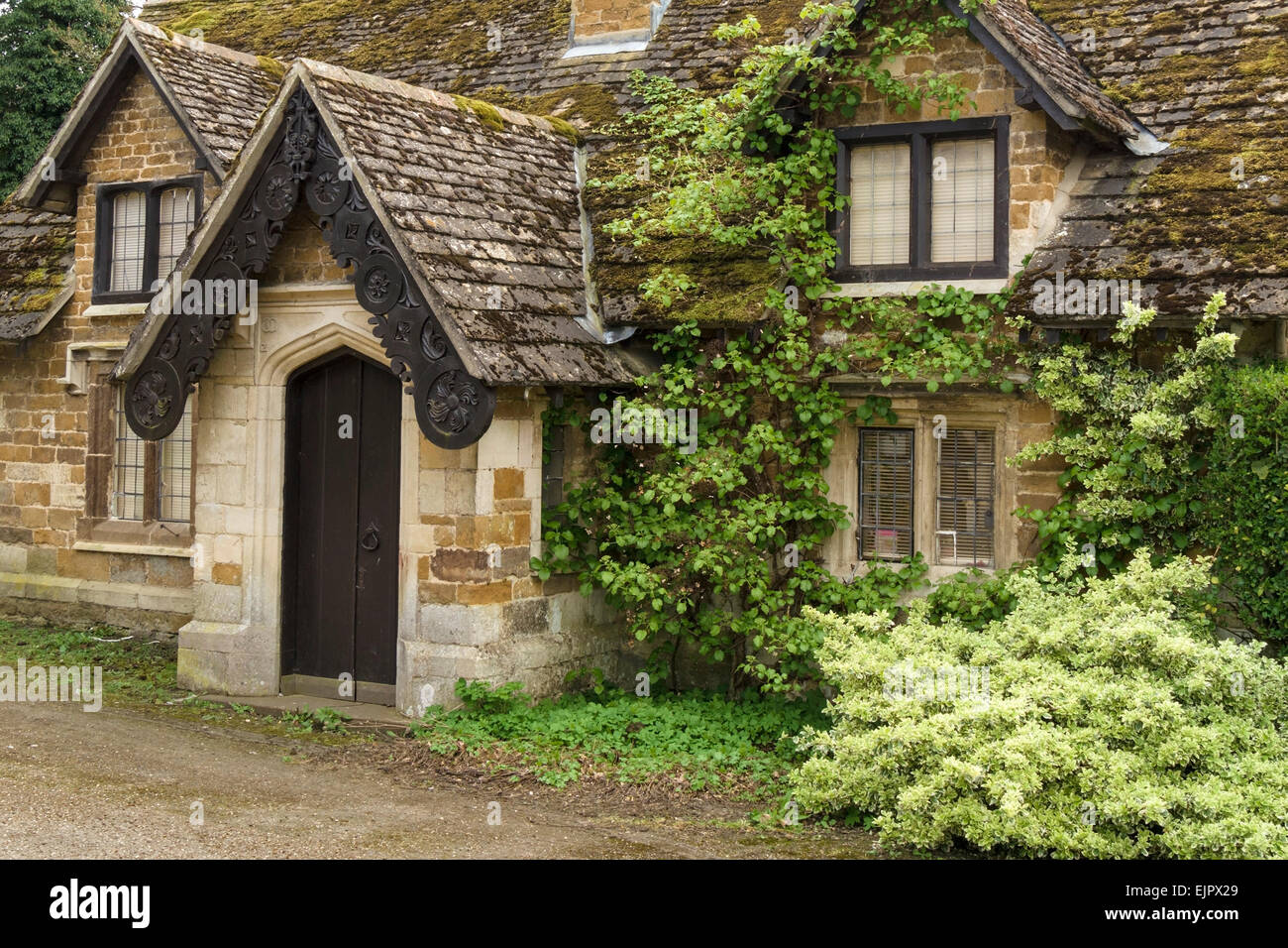 Vecchio incolto cottage in pietra ornato portico eaves, Stapleford Park, melton mowbray, leicestershire, Inghilterra, Regno Unito. Foto Stock