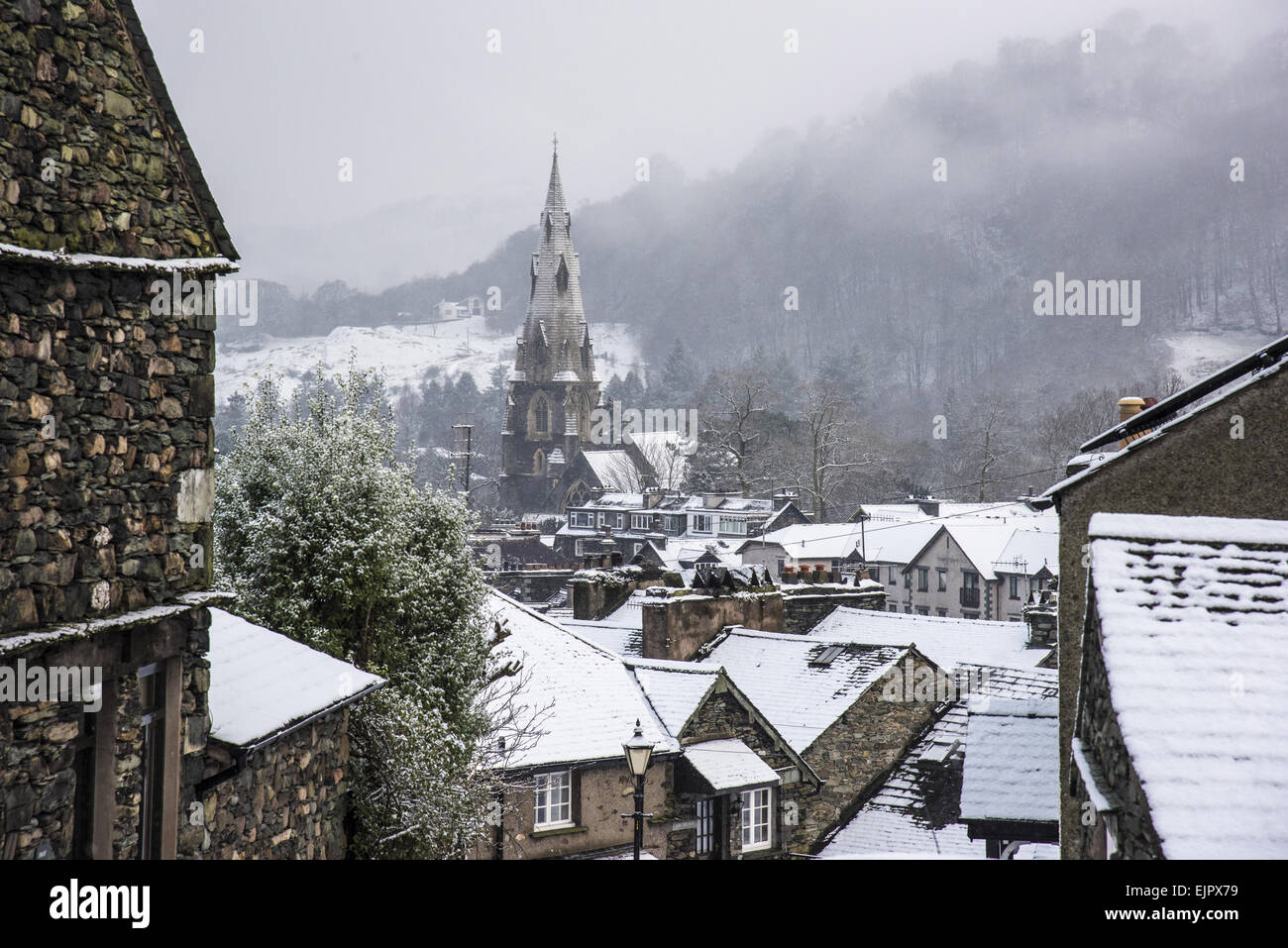 Vista su tutta coperta di neve tetti verso la chiesa la guglia in città, la chiesa di Santa Maria, Ambleside, Lake District N.P., Cumbria, Inghilterra, Gennaio Foto Stock