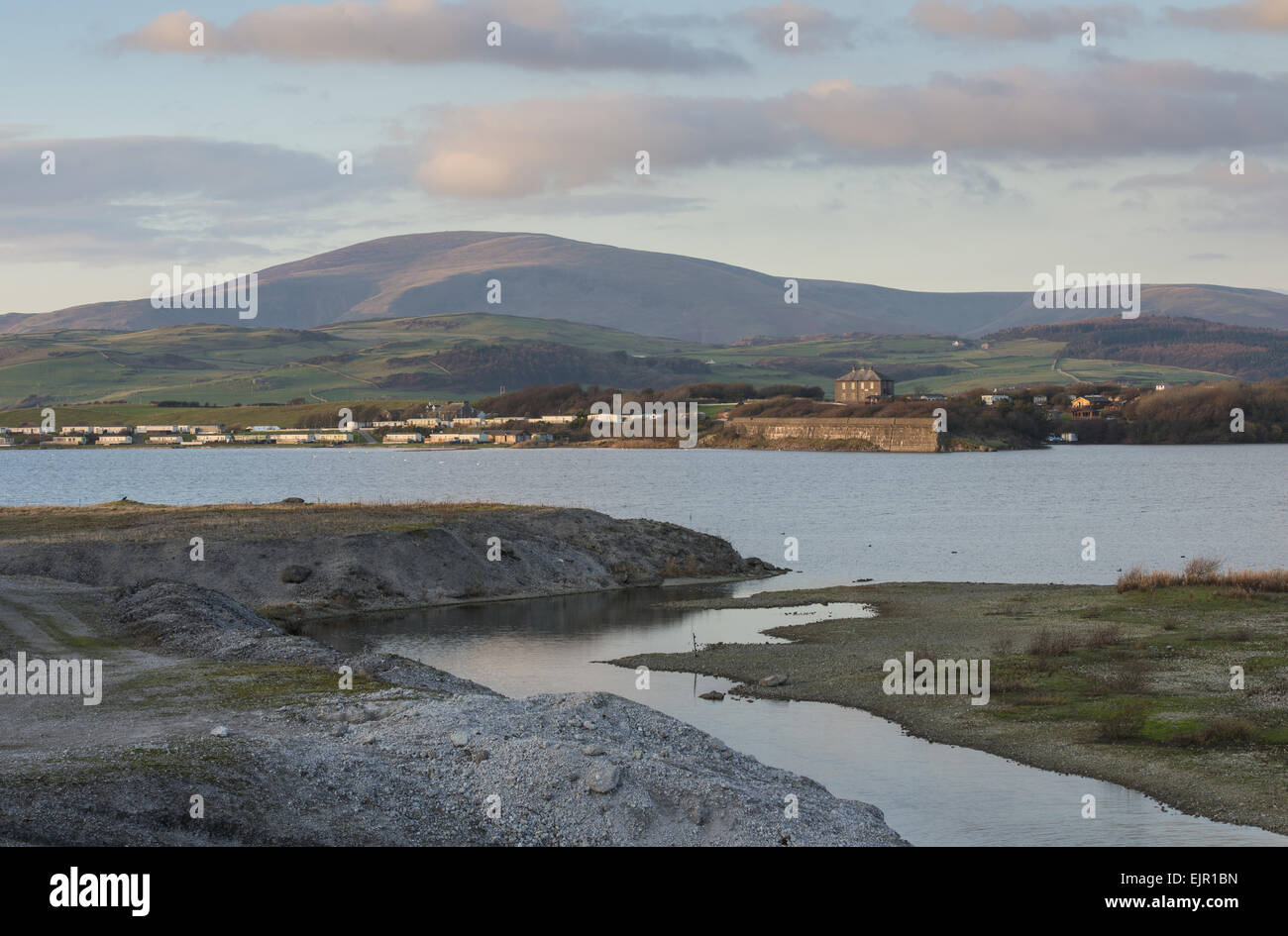 Vista di allagato ex il minerale di ferro area mineraria, circondata dal mare parete sulla periferia di Millom, Laguna Hodbarrow RSPB Riserva, Duddon Estuary, Haverigg, Cumbria, Inghilterra, Novembre Foto Stock