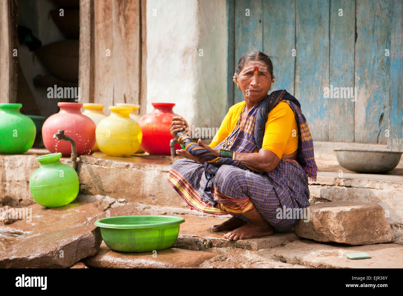 Donna anziana lavando le mani, Aihole, Karnataka, India Foto Stock