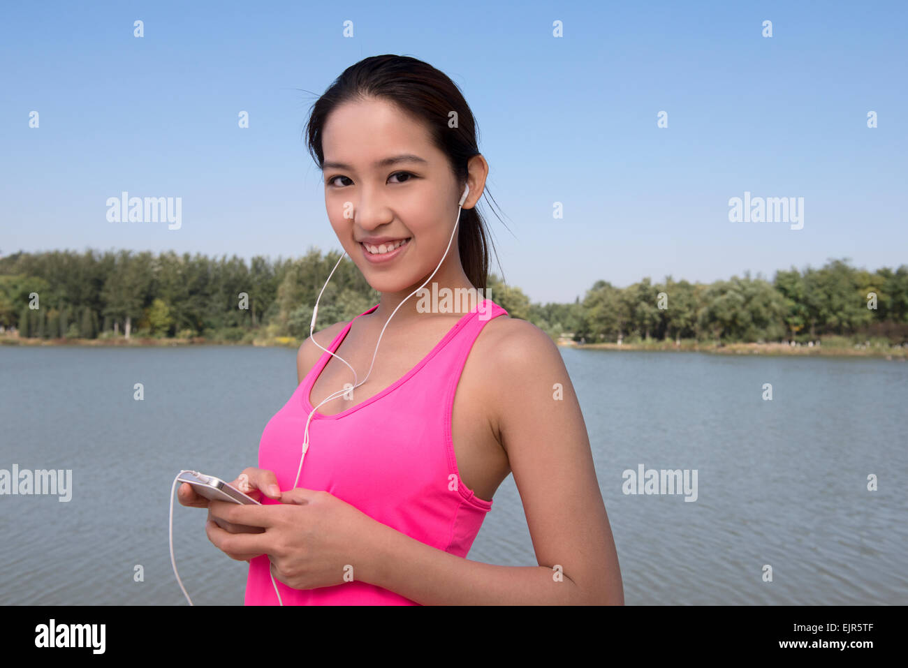 Giovane donna utilizzando smart phone durante l'esercizio Foto Stock