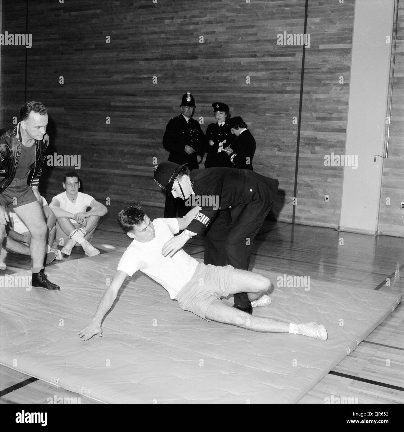 Inglese ufficiali della polizia guarda e prendere parte a una mano a mano lotta sessione di formazione presso un'accademia di polizia di New York il 2 ottobre 1964. *** Caption locale *** WatScan - - 05/01/2010 Foto Stock