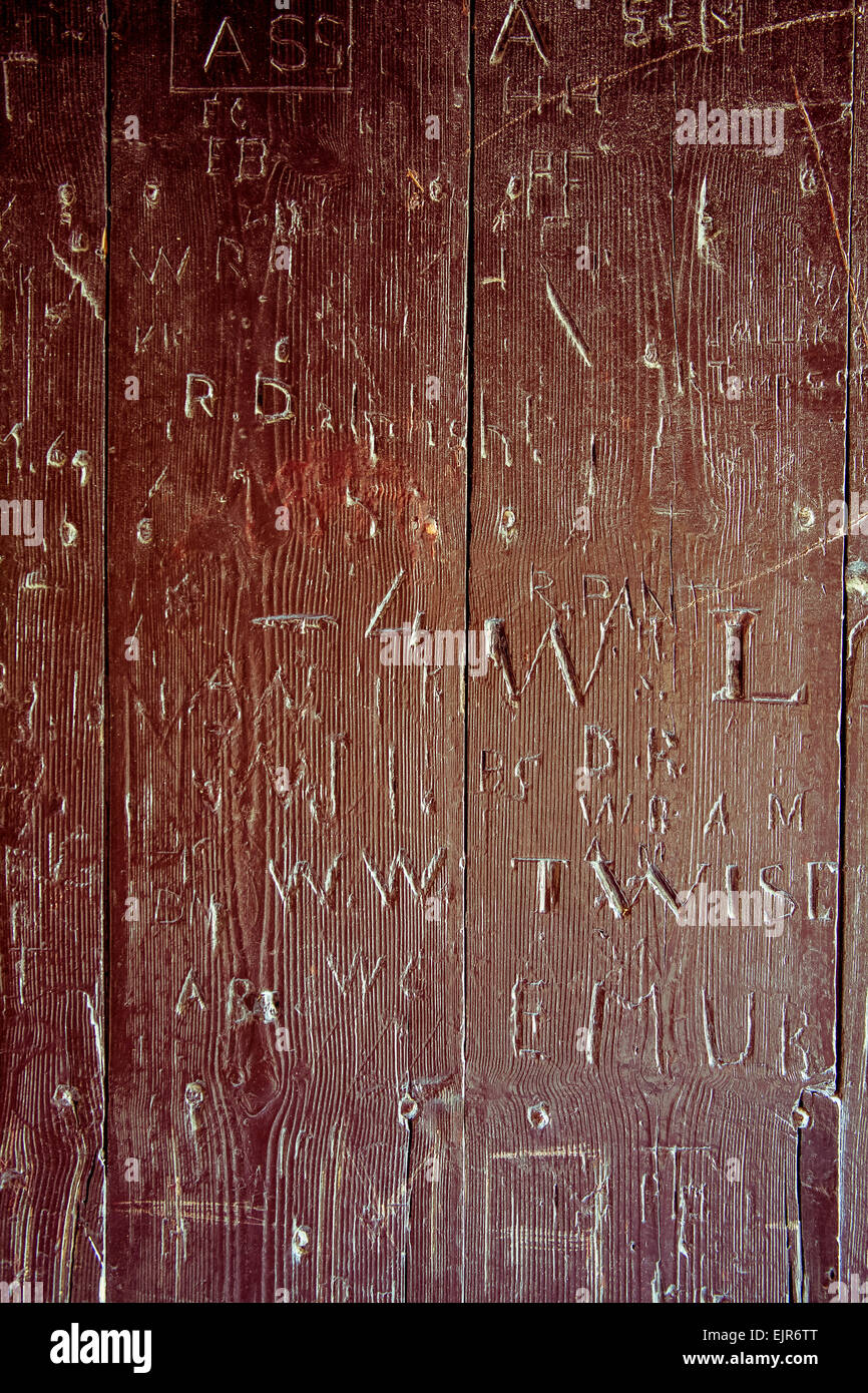 Telaio completo colpo di incisioni e graffiti su un marrone, porta di legno Foto Stock