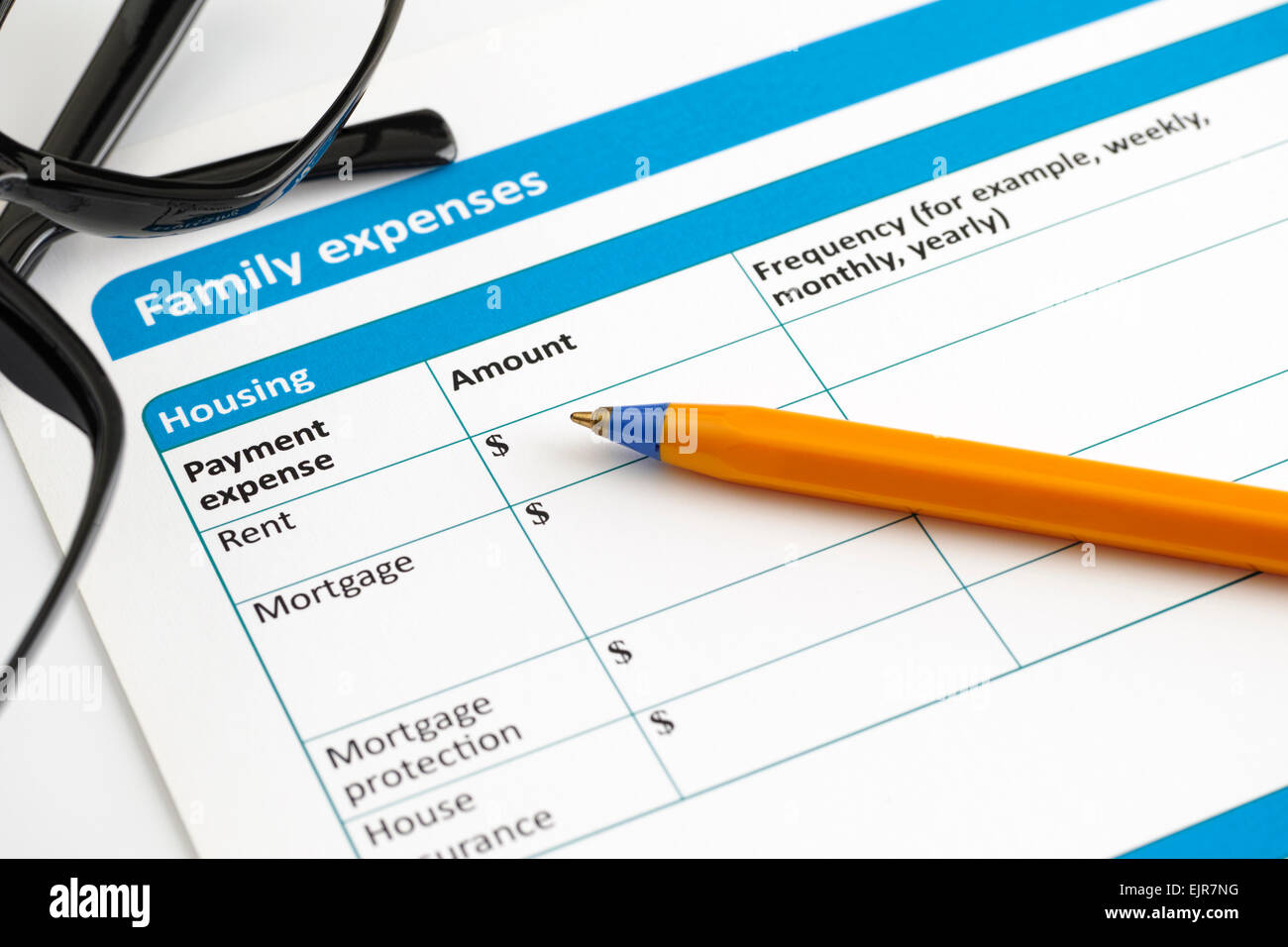 Le spese familiari sotto forma di applicazione con gli occhiali e penna a sfera. Foto Stock