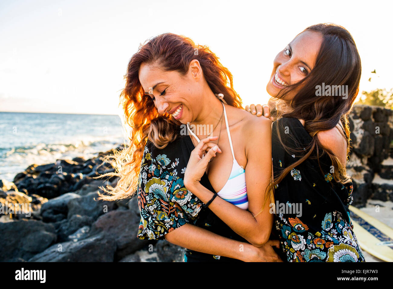 Le donne ridere sulla spiaggia rocciosa Foto Stock