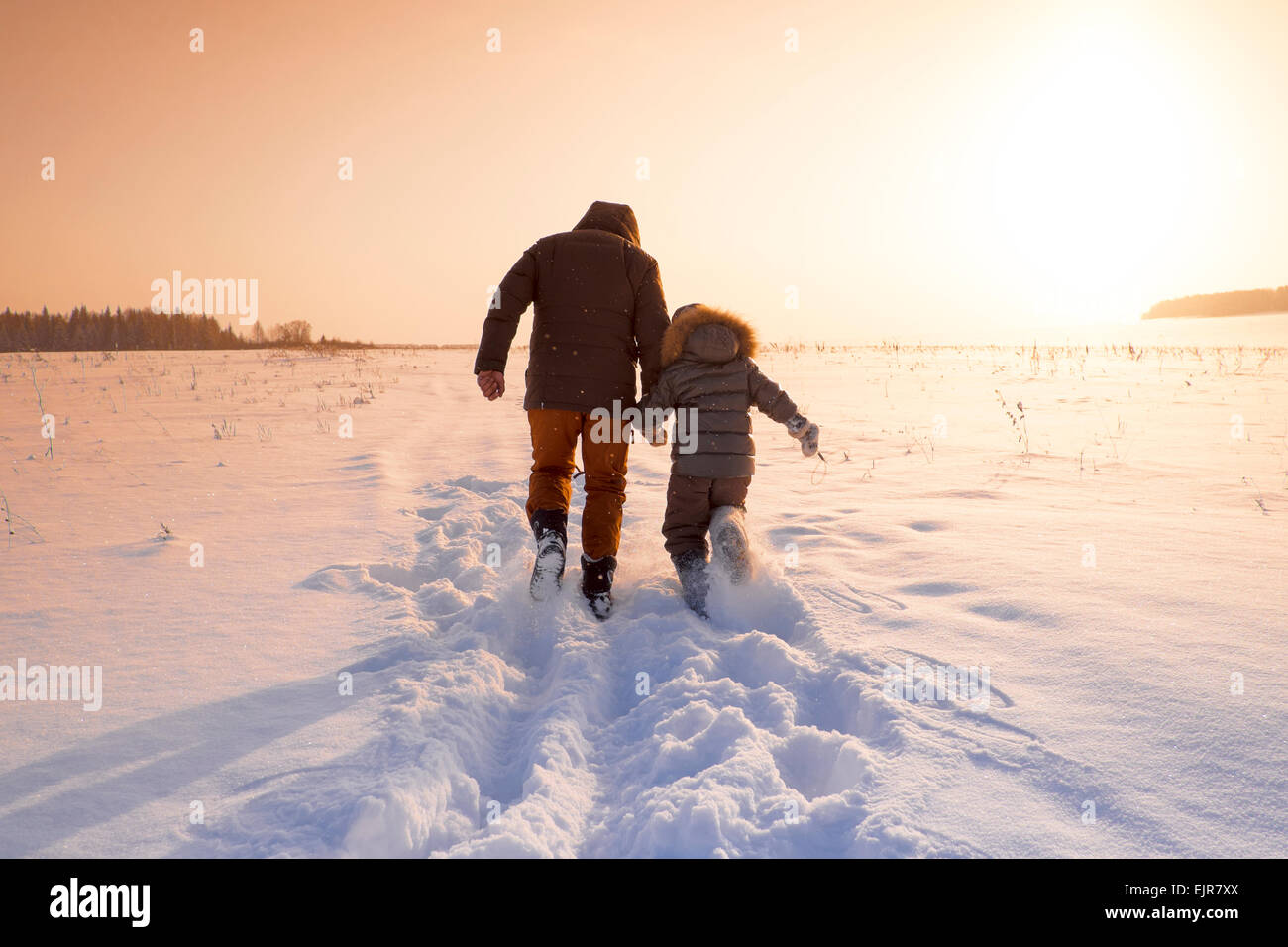 Mari padre e figlio a piedi in campo nevoso Foto Stock