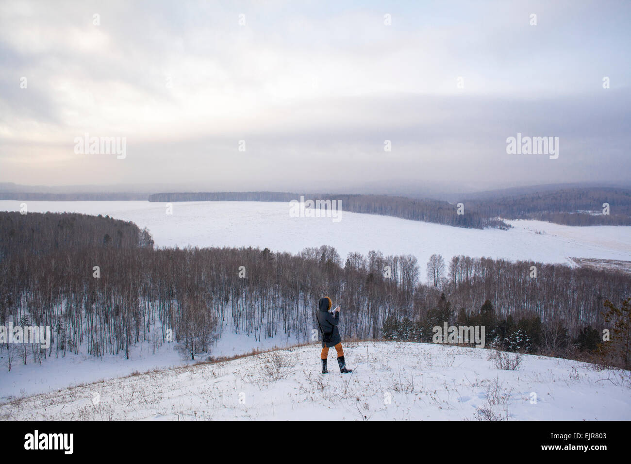 La donna caucasica permanente sulla collina nevoso Foto Stock