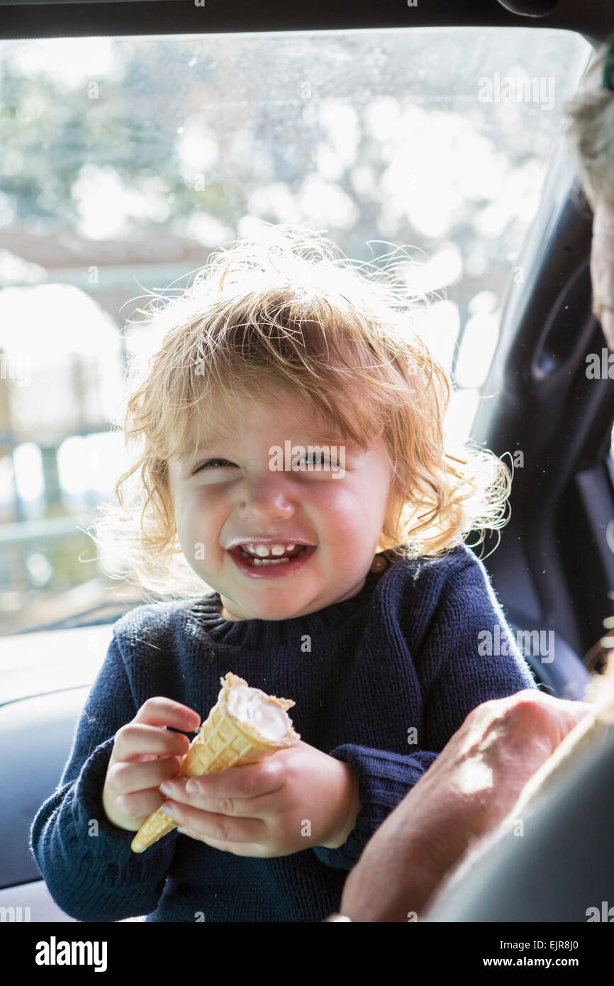 Caucasian baby boy a mangiare il gelato in auto Foto Stock
