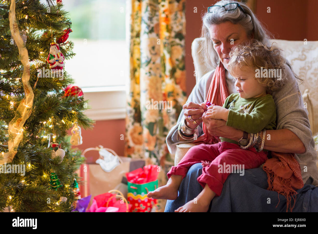 Nonna caucasica e nipote apertura presenta vicino albero di Natale Foto Stock