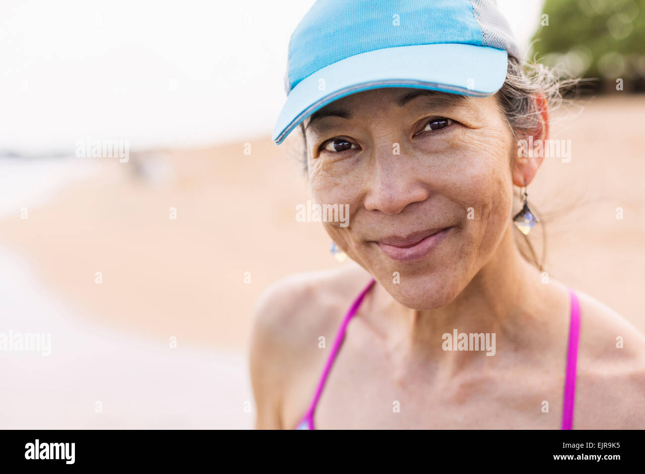 Donna Giapponese sorridente sulla spiaggia Foto Stock