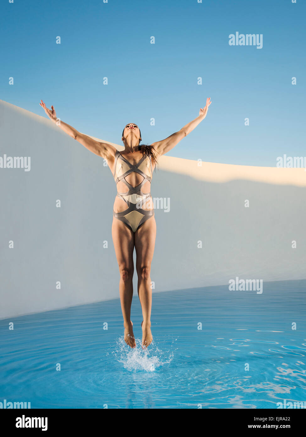 La donna caucasica salto sulla piscina Foto Stock