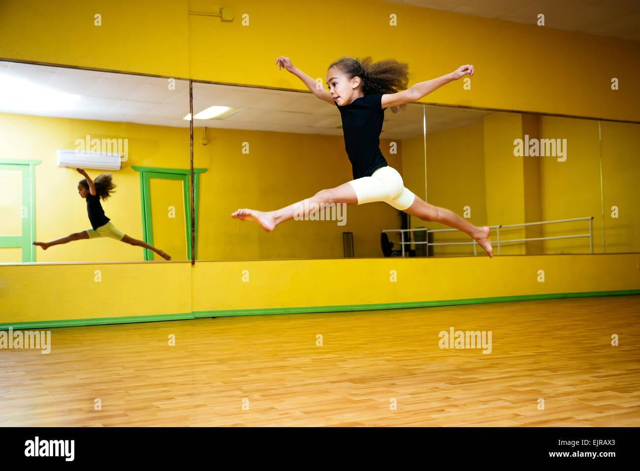 Razza mista ragazza saltando in studio di balletto Foto Stock