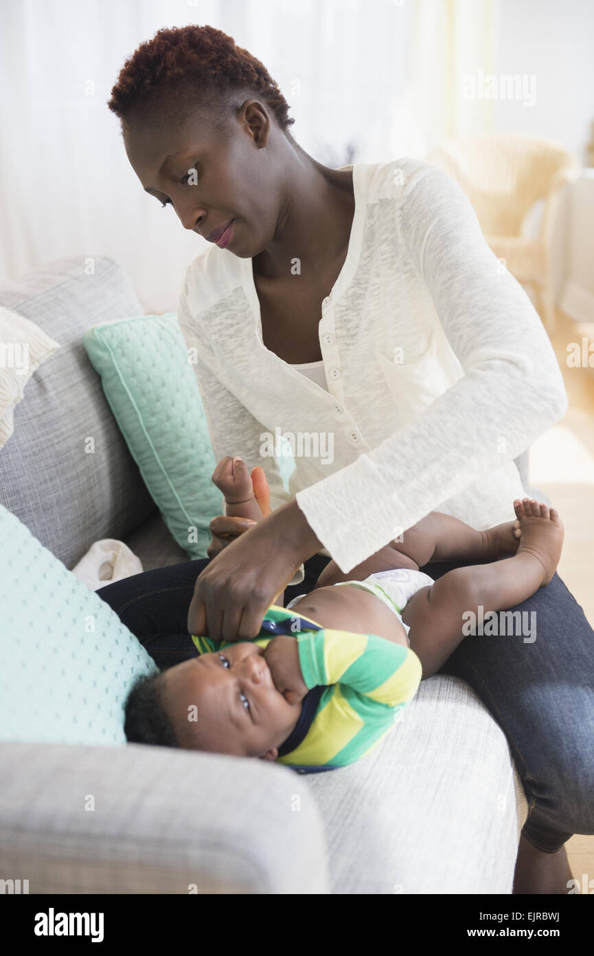 Close up della madre nera cambiando pannolino del bambino Foto Stock