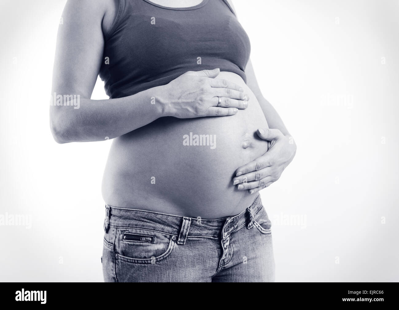 Una donna incinta mentre tiene il suo ventre, nessun volto Foto Stock