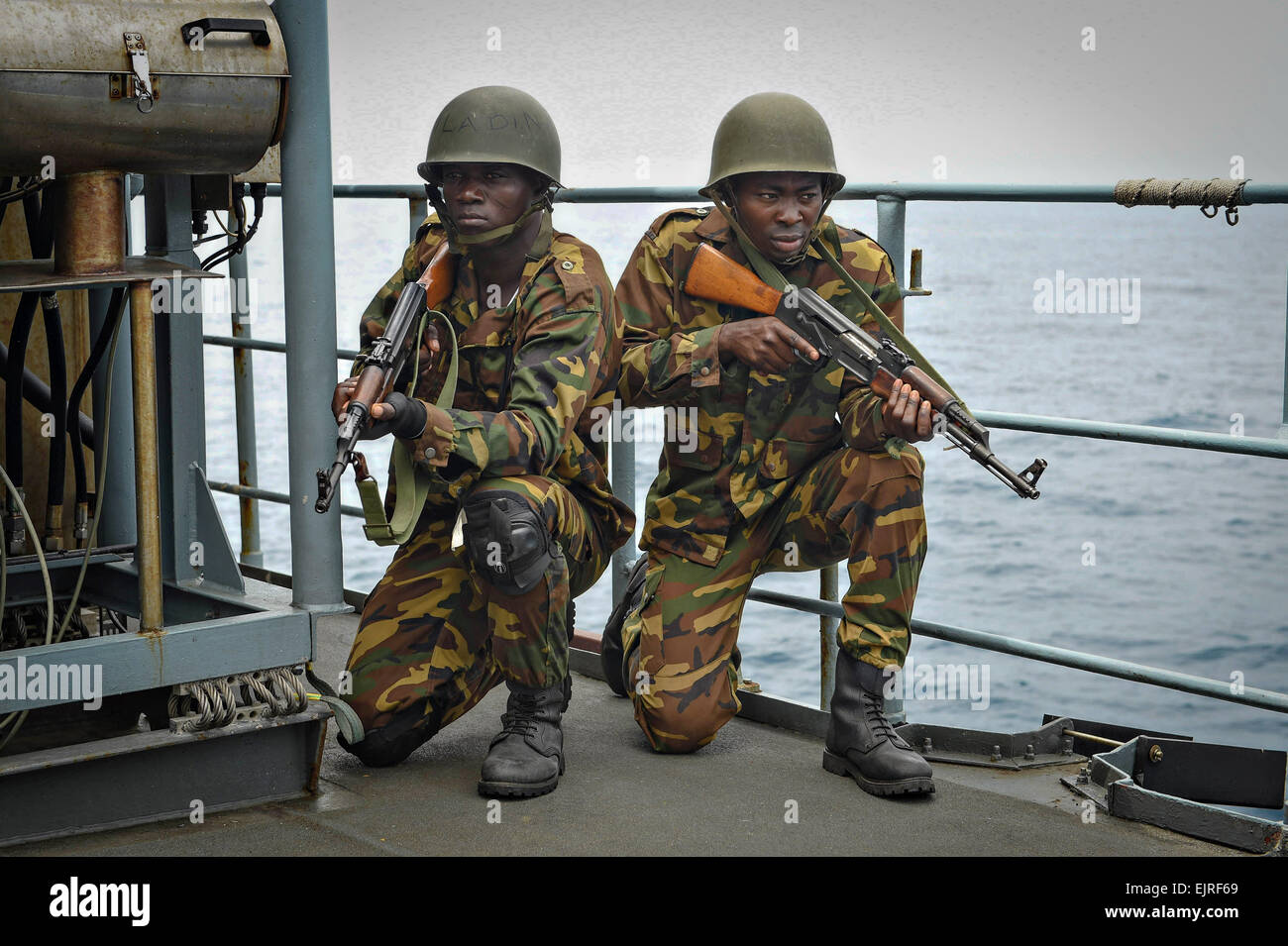 Un Togolese imbarco navale team fornisce la sicurezza di una simulazione di contrabbando di droga scenario come parte di Obangame Express a bordo della marina tedesca nave FGS Brandeburgo Marzo 26, 2015 in tema, Ghana. Foto Stock