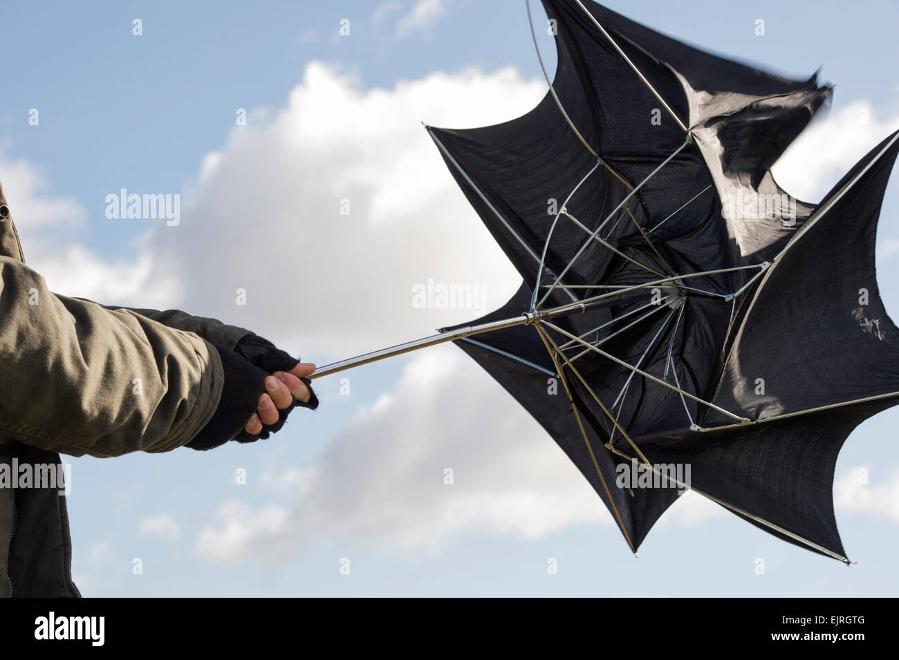 Uomo con ombrello in gale force venti Foto Stock