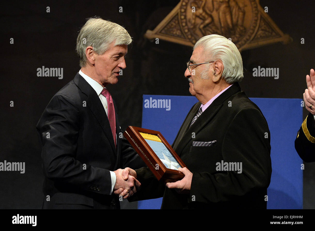 Segretario di esercito di John McHugh presenta la medaglia di Honor Flag per Charles Baldonado a nome di suo fratello Cpl. Joe R. Baldonado, uno dei 24 veterani dell esercito onorati durante il valor 24 Hall of Heroes induzione cerimonia, tenutasi al Pentagono, Washington D.C., Marzo 19, 2014. Il sig. Leroy consiglio Foto Stock