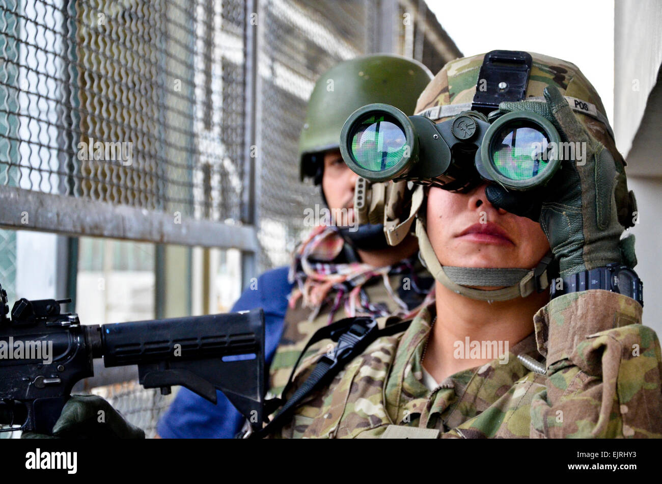 Stati Uniti Forces Afghanistan Servizio di protezione particolare Sgt. Jaclyn Guzman dalla California mantiene la sorveglianza visiva come le riprese sono licenziati ed esplosioni eruttare da un edificio a Kabul, Sett. 13. I ribelli hanno attaccato la Forza internazionale di assistenza alla sicurezza in Afghanistan la sede e gli Stati Uniti Ambasciata a Kabul, martedì, con piccole armi da fuoco al di fuori della zona sicura che circonda questi composti. Afghane e le forze della coalizione hanno intrappolato gli insorti nel parzialmente costruite, edificio multi-piano sono state usando come una posizione di sparo, e ha condotto una sistematica, piano per piano operazione di cancellazione Foto Stock