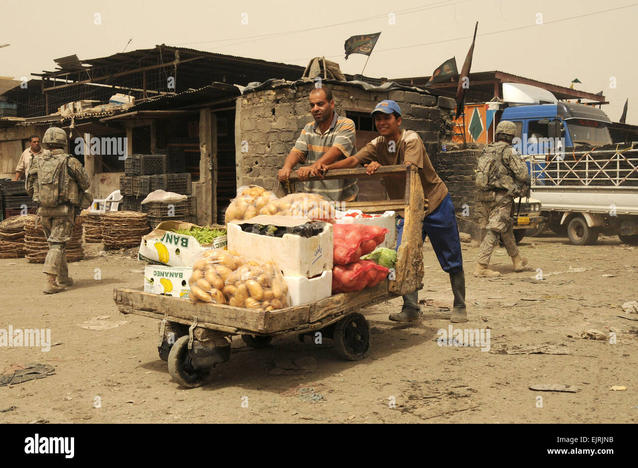 Un uomo iracheno e suo figlio il negozio nella Jameela area di mercato di Sadr City distretto di Baghdad, Iraq, 31 maggio 2008. Task Force Gold ha contribuito a ristrutturare il mercato, che è stato chiuso a causa di un problema di liquame, utilizzando una serie di progetti per rivitalizzare le parti dell'area. Tech. Sgt. Cohen A. Giovani Foto Stock