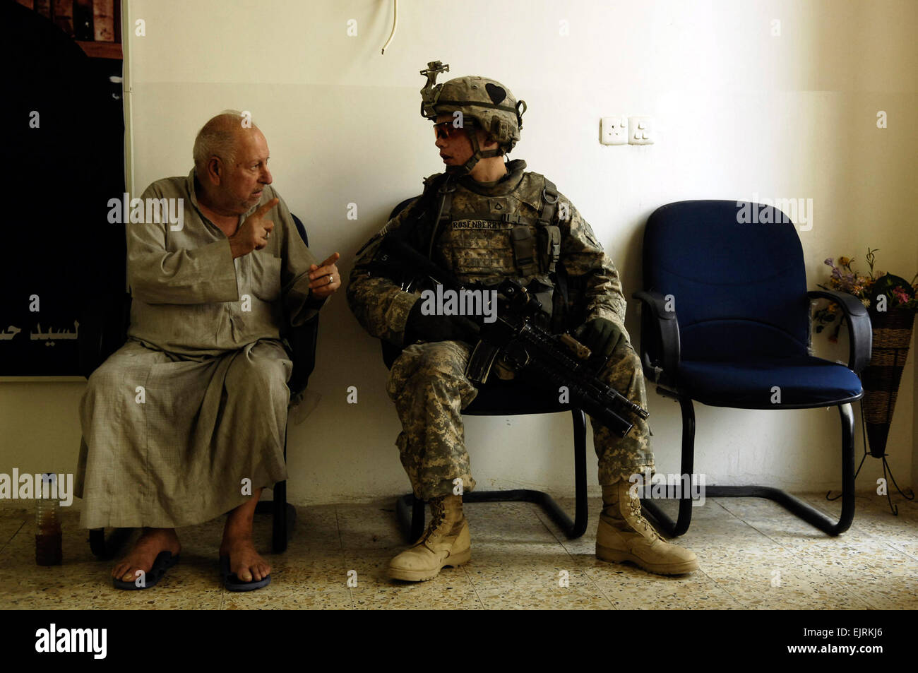 Un uomo iracheno parla di U.S. Pfc dell'esercito. Skyler Roseenberry, nativo di Chambersburg, Pa., in una sala di attesa di una casa anziani di essere visitata da parte del governo degli STATI UNITI I soldati in Kadhimiya, Iraq il 30 luglio 2008. Gli Stati Uniti I soldati sono parte del quarto plotone, Delta azienda,1° Battaglione, 502nd Reggimento di Fanteria,101st Airborne Division. US Air Force photo by Staff Sgt. Manuel J. Martinez Foto Stock
